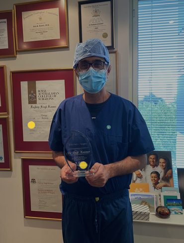 Dr Raji Kooner holding a 2000 robotic case award